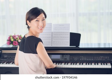 Korean lady practicing piano - Powered by Shutterstock