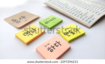 Korean learning for beginner; with focus on many Korean verb written in sticky notes and notebook. Basic verbs vocabulary for Korean language beginner level notes. In white background. 