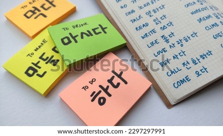 Korean learning for beginner; with focus on many Korean verb written in sticky notes and notebook. Basic verbs vocabulary for Korean language beginner level notes. In white background. 