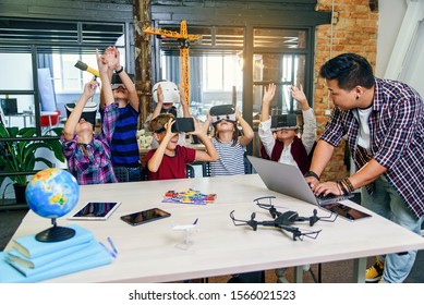 Korean male scientist with young pupils with laptop and VR headsets during a computer science class. Excited schoolchildren of smart modern school use virtual reality for studying new tecnologies. - Powered by Shutterstock