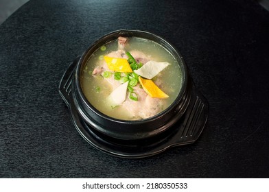 Korean Samgye Tang, Ginseng Chicken Soup, A Whole Young Chicken Filled With Garlic, Rice, Jujube, And Ginseng In Traditional Pot On Black Table Background