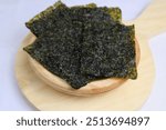 Korean seaweed salted nori sheet on wooden plate white background