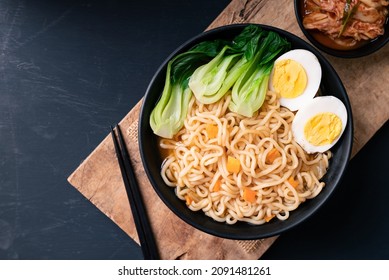 Korean Spicy Instant Noodles Soup With Bok Choy And Boiled Egg In A Bowl Eating With Kimchi