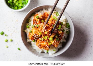 Korean tofu dubu-jorim - braised spicy bean curd with rice in a gray bowl, light background, top view. Asian vegetarian food concept.