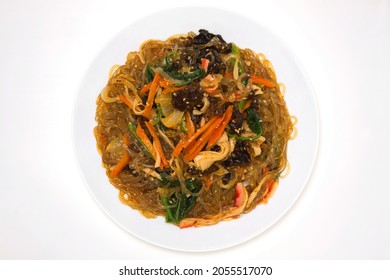 Korean Traditional Holiday Food 'Japchae'. Consisting Of Cellophane Noodles Made From Sweet Potato Starch, Stir-fried With Vegetables. Isolated On White Background. Top View.
