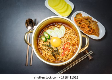 Korean traditional Ramyeon noodle  with egg yolk, chilli, kimchi in a traditional korean noodle pot, Spicy Korean Ramyeon instant noodle a traditional dish.
