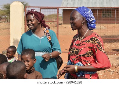 Korr, North Kenya, January 2016. Kenyan Teachers Singing A Traditional Song With A Group Of Children In Front Of A School. Education In Developing Countries. 