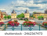 Kortrijk cityscape with Lys river, Broel Towers Gothic style buildings and Bridge in historical centre, red flowers on bridge fence, Fortification towers, belgium landmark, Flemish Region, Belgium