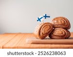 Korvapuusti, traditional finnish cinnamon and cardamom rolls, fresh baked buns on the wooden board, sweet dessert Sweden and Finland, horizontal banner with copy space for holiday