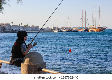 Kos , Greece- September 2019: Old Woman  Fishing