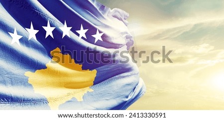 Kosovo national flag waving in beautiful clouds.