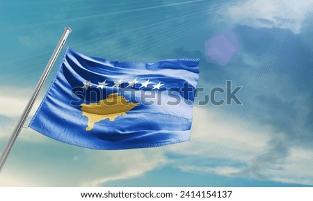 Kosovo national waving flag in beautiful clouds.