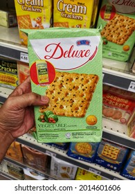 Kota Kemuning, Malaysia - 18 July 2021 : Hand Hold A Packed Of DELUXE Vegetable Crackers For Sell In The Supermarket With Selective Focus.