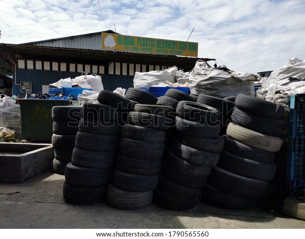 Kota\
Kinabalu,Sabah/Malaysia - August 2nd 2020 : Selective focus on\
image of used automobil tires stacked on workshop concrete floor.\
Image may contain noise or grain due to low\
light.