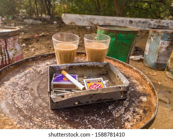 Kota, Rajasthan, India 15 December 2019 - Two Tea Glass Image With Cigarettes On A Tea Shop Or Tea Stall