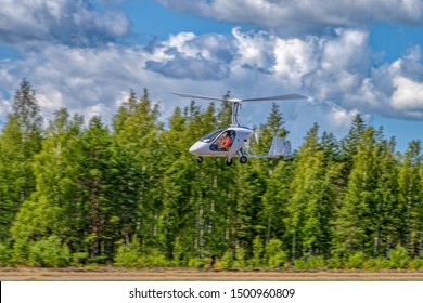 KOTKA, FINLAND - Aug 10, 2019: Italian sport autogyro Magni M-24 Orion (OH-G016) with two side-by-side seats in an enclosed cabin take off from Kymi (EFKY) airfield.
