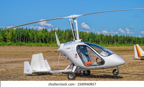 KOTKA, FINLAND - Aug 10, 2019: Italian sport autogyro Magni M-24 Orion (OH-G016) with two side-by-side seats in an enclosed cabin displayed at Kymi (EFKY) airfield.