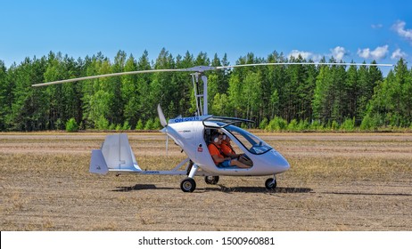 KOTKA, FINLAND - Aug 10, 2019: Italian sport autogyro Magni M-24 Orion (OH-G016) with two side-by-side seats in an enclosed cabin prepare to fly at Kymi (EFKY) airfield.