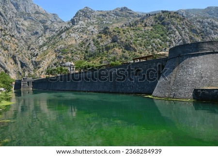 Kotor, city walls with water-filled moat around the old town, with mountains in the background, Kotor, Montenegro