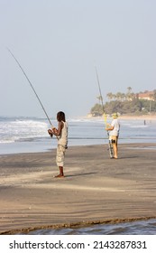 KOTU, SERREKUNDA, THE GAMBIA - FEBRUARY 5, 2022 Black And White Man Fishing From The Beach