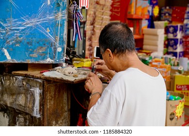 Kowloon, Hong Kong - 17 September 2018: A Local Shop Keeper Working To Fix A Watch.