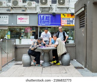 Kowloon, Hong Kong - October 2019: Senior Citizens Play Xiangqi Aka Chinese Chess With Their Friends Watching Sitting In A Park Outdoor.