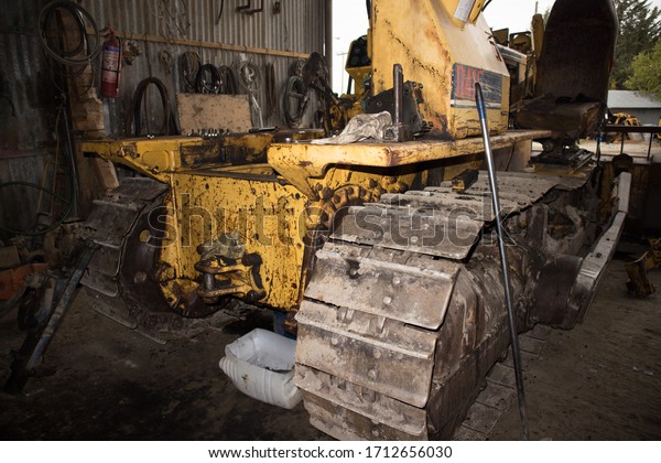 Kozani, Greece -\
October 2019: A small yellow heavy machinery, with metallic stripes\
for wheels. For repair.