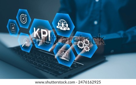 KPI, Analyzing Key Performance Indicators. Businessman using laptop to analyze key performance indicators (KPIs) displayed as holographic icons, representing business metrics, and performance analysis