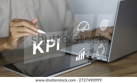 KPI (Key Performance Indicator) concept showing a professional businessman using a digital tablet and laptop to monitor corporate performance metrics. The image features high-tech holographic icons representing financial growth, target hitting, speedometers for efficiency, and ROI (Return on Investment) cycles. This visual illustrates modern business intelligence, strategic planning, data-driven decision-making, and digital transformation in a corporate office setting. It is ideal for themes related to management, productivity tracking, marketing success, and financial analysis