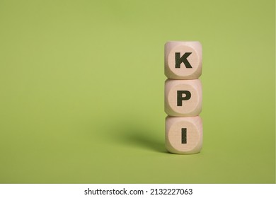 KPI, Key Performance Indicators acronym letters on wooden blocks isolated on light green background copy space