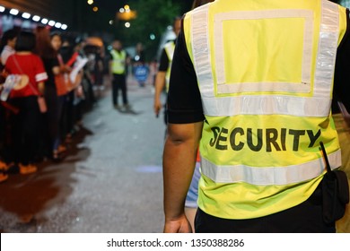 K-Pop Music Theme Security Guard With Blurred Crowd Of Audience Or Diversity People At Concert Venue Entrance. Enjoy Music And Entertainment Concept. (selective Focus, Space For Text, Article Layout)