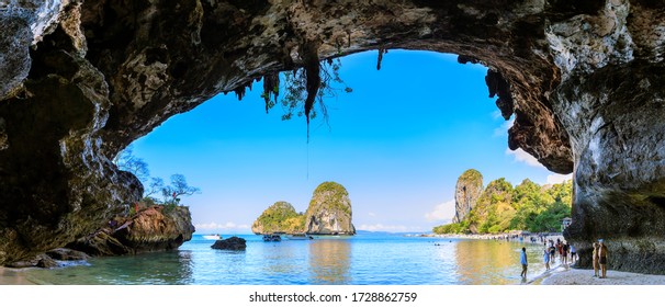 Krabi, Thailand - February 16, 2020: Majestic cave and limestone cliff mountain at Phra Nang Beach, famous tourists destination.