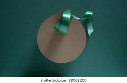 Kraft Paper Cake Box With Green Ribbon On Dark Green Background