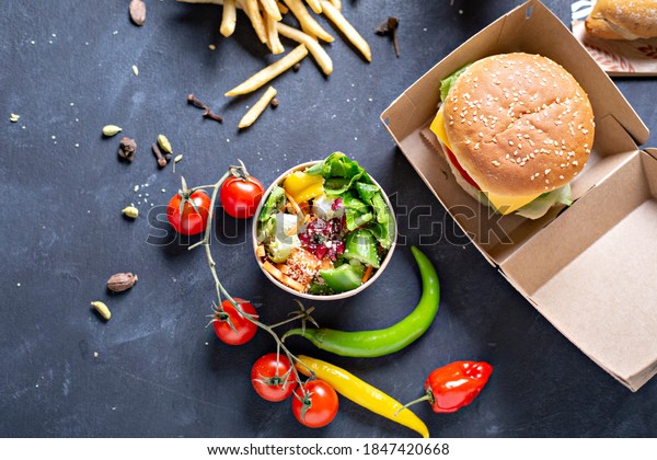 kraft paper food\
packaging boxes for burgers and  french fries, salad, nagets. on a\
black background. - image