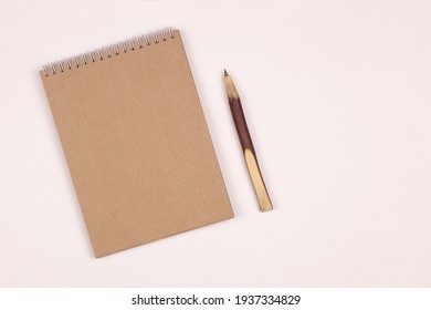 Kraft Paper Notebook And Wooden Pen On White Background