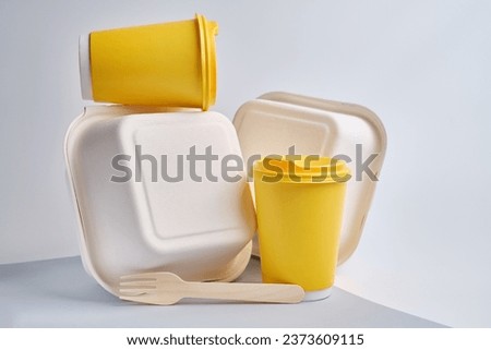 Kraft paper tableware: cups, food boxes, wooden forks isolated on a light background. A set of various disposable tableware. Recycling and zero waste concept. Mock up 