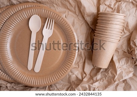 Kraft paper tableware: cups, food boxes, isolated on a light background. A set of various disposable tableware. Recycling and zero waste concept. Mock up