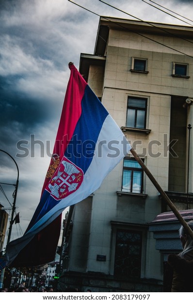 Kragujevac,\
Serbia.\
11.27.2021. Anti- government demonstrations with Serbian\
flag in the center. Crowd of people protesting around police.\
Selective focus, concept\
photos.