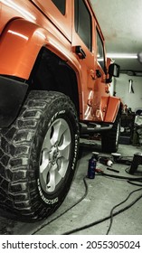 Kragujevac, Serbia. 28.09.2021. Indoor Car Photoshoot, Orange Jeep Wrangler In Selective Focus-Orange Jeep In Car Detailing Studio, Back Side, Strong Contrast.