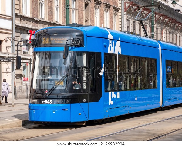 Krakow, Malopolska, Poland - February 2022:\
Krakow, Poland, blue Krakowiak tram, vehicle front closeup, modern\
public transportation, city transport, commute, MPK tramway\
infrastructure concept