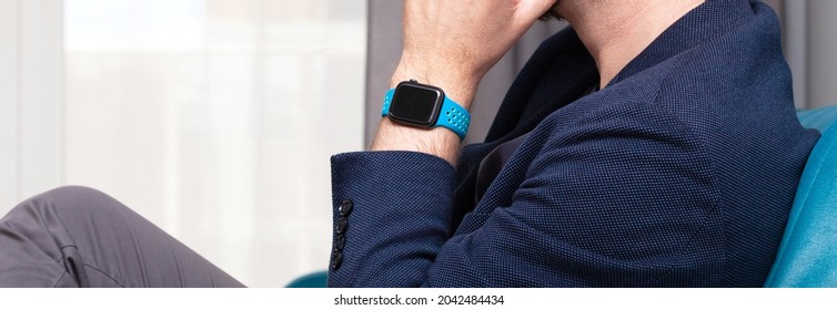 Krakow, Malopolska, Poland - July 2021: Anonymous Unrecognizable Man Wearing An Apple Watch On His Wrist Wide Shot, Closeup, Hand Under Chin. Apple Company, IOS System, Personal Gadgets, Accessories