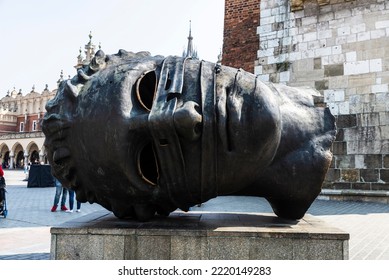 Krakow, Poland - August 28, 2018: Eros Bendato Or Eros Bound, Giant Head Bronze Statue Next To The Rynek Underground Museum In The Main Market Square With People Around In Krakow, Poland