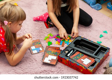 Krakow, Małopolska, Poland - February 2021: Two Little School Age Girls Playing A Game Of Ubongo Together. Family Activities While Staying At Home, Children Board Games, Sisters, Siblings Togetherness