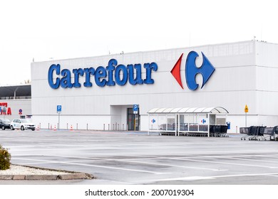 Krakow, Małopolska, Poland - May 2021: Krakow, Poland, Carrefour supermarket store front logo signage closeup. Empty parking in front of the store building, nobody. Carrefour retail company, brand