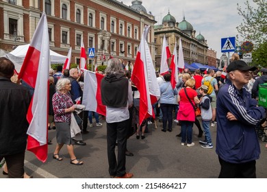 KRAKOW, POLAND - MAY 3, 2022: Crowd of people holding flags of Poland during 3 May Polish Constitution Day patriotic parade. Celebration of the 3rd May National Holiday in Kraków.