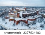 Krakow skyline with historic royal Wawel Castle and Cathedral in winter. White snow, walking people and promenade