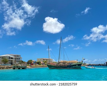 Kralendijk, Bonaire, Caribbean Netherlands -2022: Samur Siamese Junk Boat. Hand carved wood boat. A junk type of Asian sailing ship with fully battened sails. Approaching zodiac inflatable tender. 