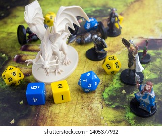 Krasnodar, Russia, 23 May 2019: Playing Dungeons And Dragons Game. Map With A Figure Of Dragon And Plastic Figures Of Rpg Characters, Dices Scattered. 