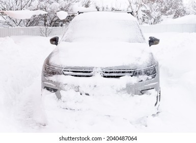 KRASNODAR, RUSSIA - February 16, 2021: Snow-covered Volkswagen Tiguan Car On House Driveway After Snowfall. Winter Weather