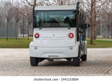 Krasnodar, Russia - March 22 2021: Electric Vehicle With Zero Emission Stands In The Park. The Road Is Paved With Cobblestones. Compact Electric Utility Vehicle To Transport Guests To An Event.